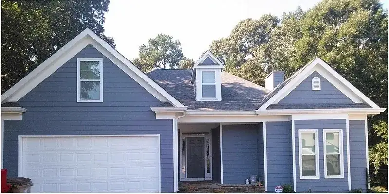 Completed home exterior with new blue fiber cement siding and white trim by EZY Exteriors